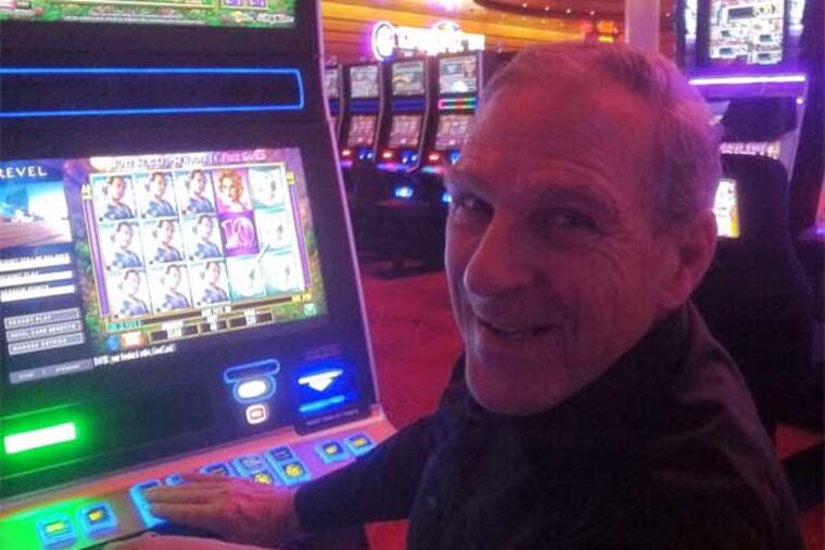 David Roslin of Reading plays a penny slot machine at Revel. He said that a buffet and smoking area were needed at the casino. (Suzette Parmley / Staff)