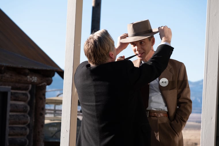 Christopher Nolan adjusts Cillian Murphy's hat to achieve the precise Oppenheimer look.