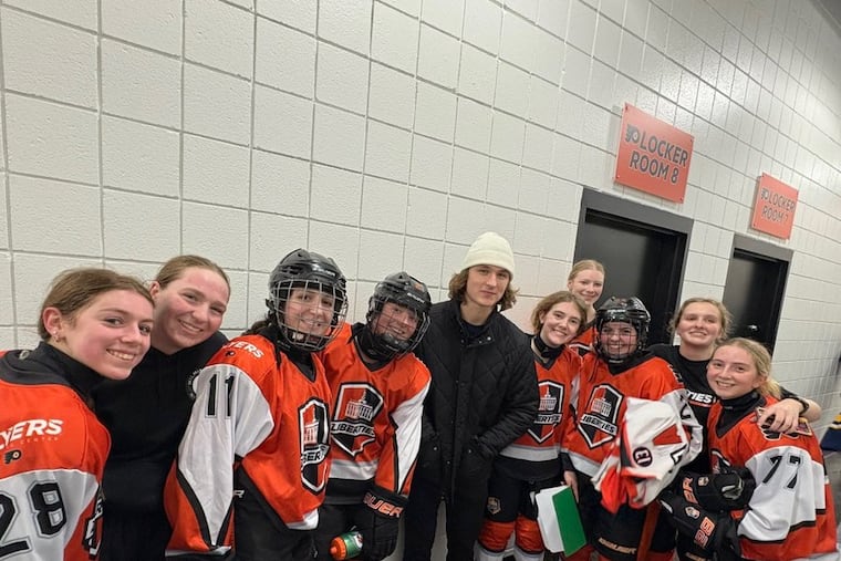 Flyers center Trevor Zegras (center) stops by a Philadelphia Liberties practice at the Flyers Training Center.
