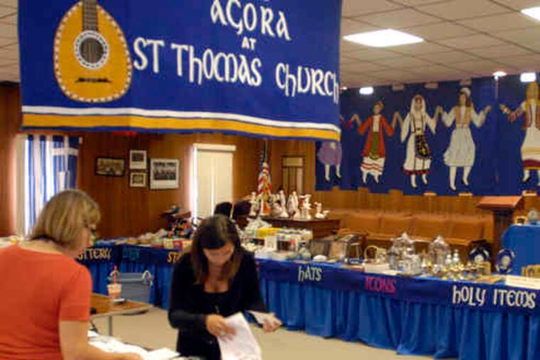 At the Greek Orthodox Church of St. Thomas , volunteers Linda Kontoulis (left) and Carmela Roustas prepare for the sale of items at the Agora Greek Festival, which runs through Sunday.