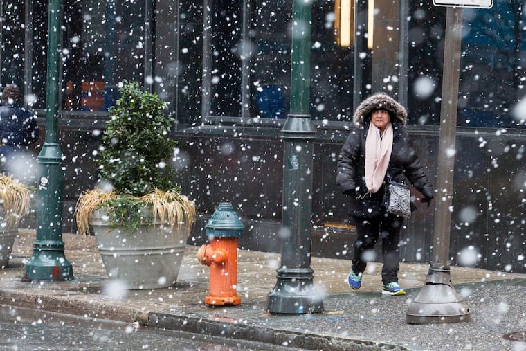 Pedestrians make their way across 16th Street near Chestnut Street at the start of last week’s storm.