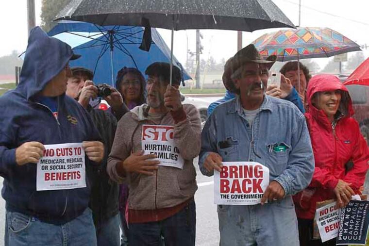 Rain-soaked protesters are listening organizer, Innes Forbes' speech on the sidewalk.
10-11-2013( AKIRA SUWA / Staff Photographer )
Protesters from Boldprogressive.Org who are against US Gov. shutdown demonstrating in front of the office of Congressman, Pat Meehan at Springfield, PA.