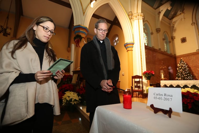 Lourdes Gonzalez-Sherby reads a prayer Saturday as Father Mike McCue lights one of 22 candles at a vigil at Cathedral of the Immaculate Conception to honor the homicide victims in Camden in 2017. DAVID SWANSON / Staff Photographer