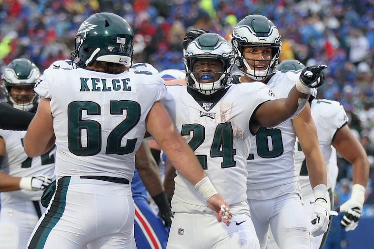 Eagles running back Jordan Howard (24) celebrates his fourth-quarter touchdown with center Jason Kelce (62).