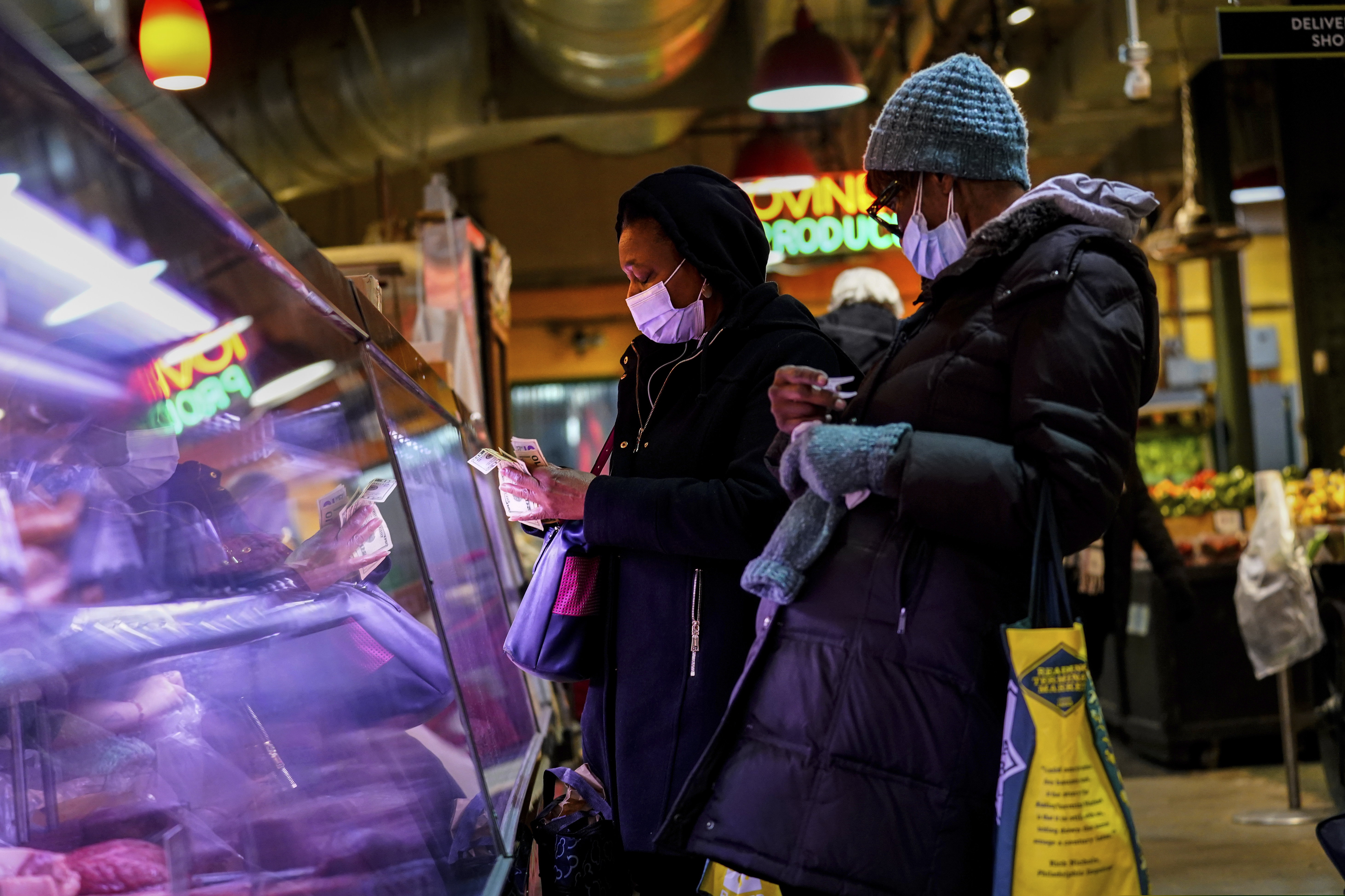 Customers wearing face masks to protect against the spread of the coronavirus shop at the Reading Terminal Market in Philadelphia, Wednesday, Feb. 16, 2022. Philadelphia city officials lifted the city's vaccine mandate for indoor dining and other establishments that serve food and drinks, but an indoor mask mandate remains in place. Philadelphia Public Health officials announced that the vaccine mandate was lifted immediately Wednesday.