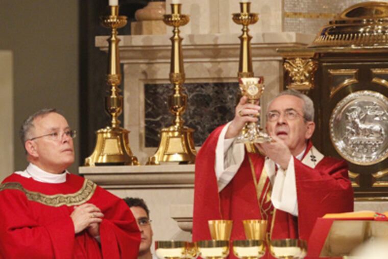 Archbishop Charles J. Chaput (left) assists Cardinal Justin Rigali in his first Mass offered at the Cathedral Basilica of SS. Peter and Paul. (Charles Fox / Staff Photographer)