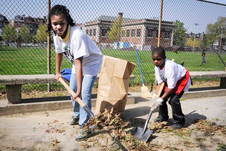 Volunteers clean the sidewalk at Kingsessing Recreation Center during a previous spring cleanup.