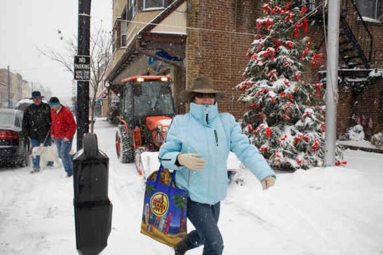 Caroline Talarico of Media runs ahead of a plow cleaning the sidewalk on State Street. She was out doing holiday errands yesterday. "I just love this," she said.