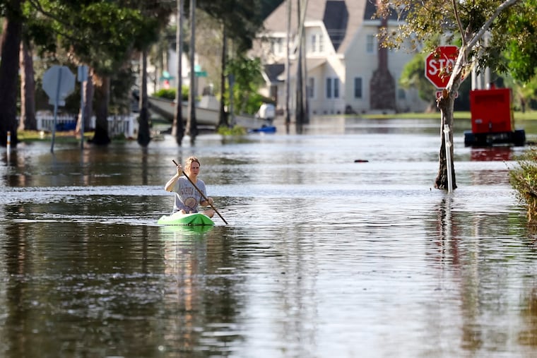 Halle Brooks kayaks down a street flooded by Hurricane Helene in St. Petersburg, Fla., on Friday.