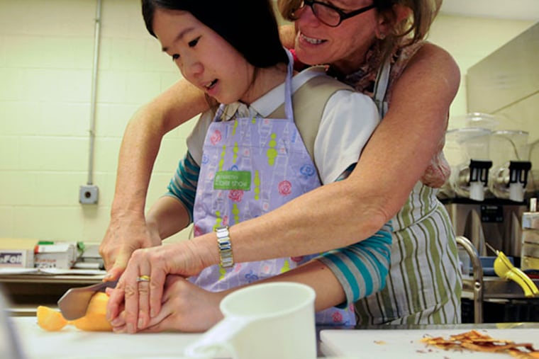 Maureen helps Kimberly Luu slice a sweet potato to make sweet potato and carrot soup on April 9, 2014. ( RON TARVER / Staff Photographer )