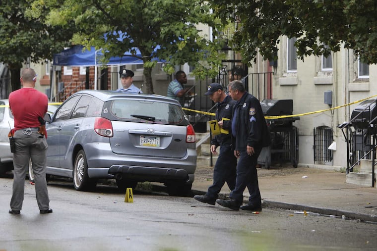 Police investigate the crime scene on Fairhill Street near Diamond Street, Monday, Aug. 7, 2017, after Philadelphia police officers shot a man they say pointed a handgun at two officers who responded to a "person with a gun" call shortly after 4:30 p.m. Monday, according to police.
