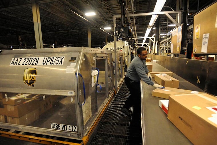 At UPS's Hog Island Road facility, a worker sorts international packages into containers. The facility employs 3,100 people of the company's regional workforce of 5,287. ( RON TARVER / File Photo )