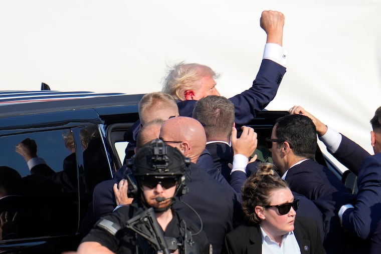 Republican presidential candidate former President Donald Trump pumps his fist as he is helped into a vehicle at a campaign event in Butler, Pa., on Saturday.