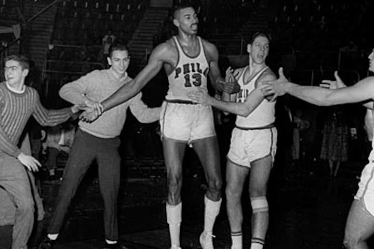 Fans and teammates surround Wilt Chamberlain to congratulate him after his 100-point game in 1962. (AP file photo)