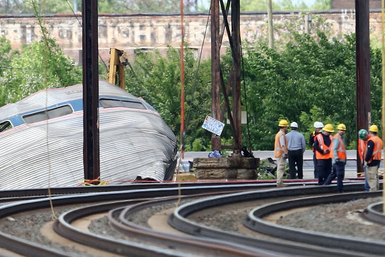 Investigators at the scene of the derailment Wednesday. DAVID SWANSON / Staff Photographer