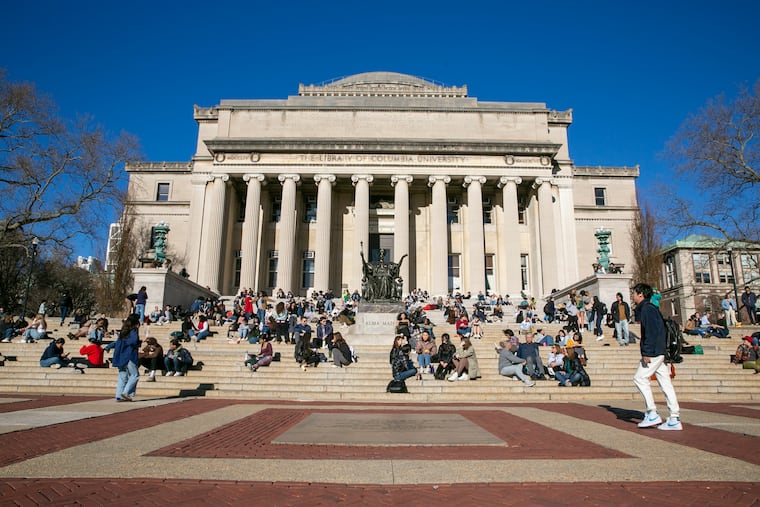 Students sit on the front steps of Low Memorial Library on the Columbia University campus in New York City, Feb. 10, 2023.