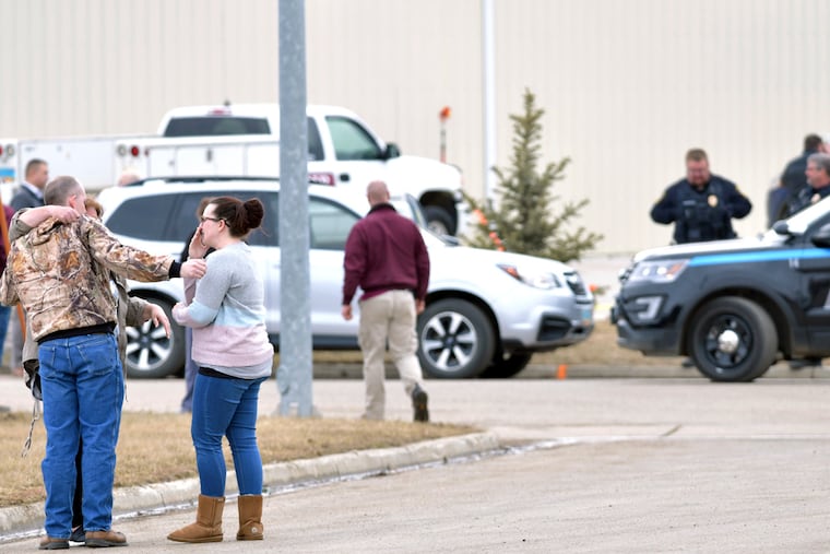 Family and friends console each other at the scene near the south side of the RJR Maintenance & Management building in Mandan, N.D., Monday, April 1, 2019. (Mike McCleary / The Bismarck Tribune via AP)