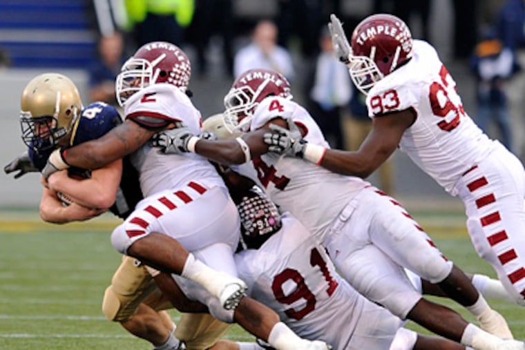 Navy's Vince Murray is brought down by a host of Temple defenders during the Owls' 27-24 win. (AP Photo/Gail Burton)