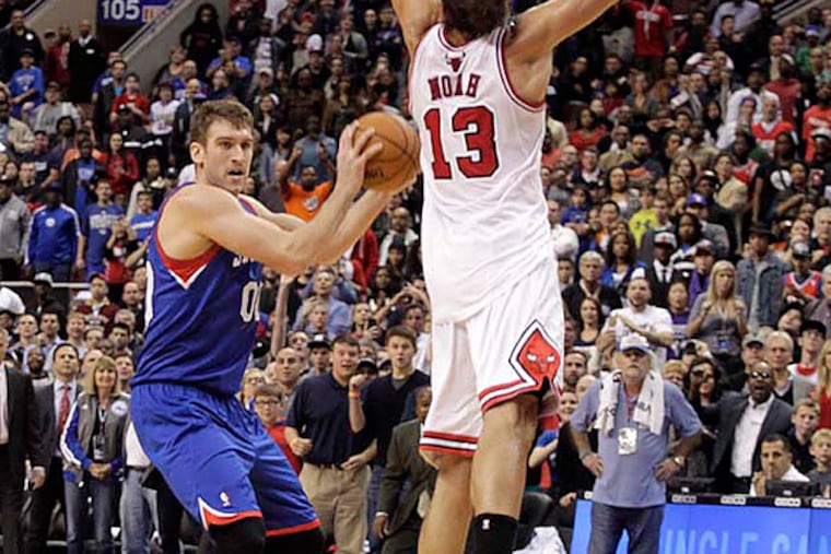 Chicago Bulls' Joakim Noah (13) defends as Philadelphia 76ers' Spencer Hawes (00) sets up to shoot a three. (AP Photo/H. Rumph Jr)