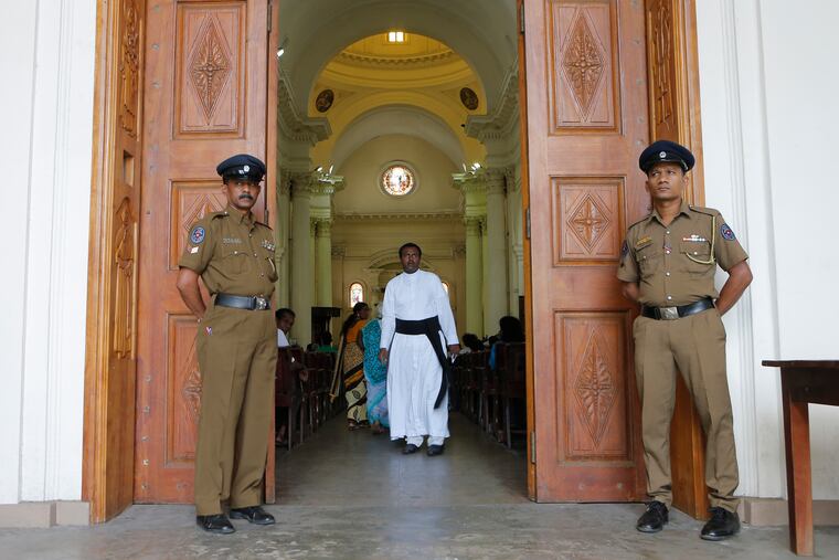 Sri Lankan police officers stand guard at the entrance to St. Lucia's cathedral during a holy mass held to bless victims of the Easter Sunday attacks in Colombo, Sri Lanka, Saturday, May 11, 2019. More than 250 people were killed when suicide bombers struck three churches and three tourist hotels on Easter. Masses at churches were canceled for a second week last Sunday and the reopening of schools was postponed after reports warned of possible new attacks. (AP Photo/Eranga Jayawardena)