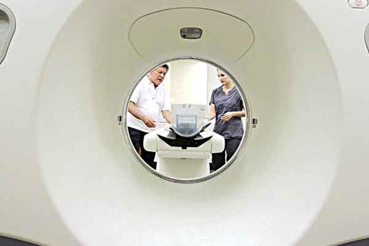 Hope Veterinary Specialist's medical director Dennis Burkett (left) and Crystal King, head surgical tech, begin set up of the CT scanner in the CT room of Hope's new $4.5 million veterinary hospital in Malvern on May 31, 2013. ( ELIZABETH ROBERTSON / Staff Photographer )