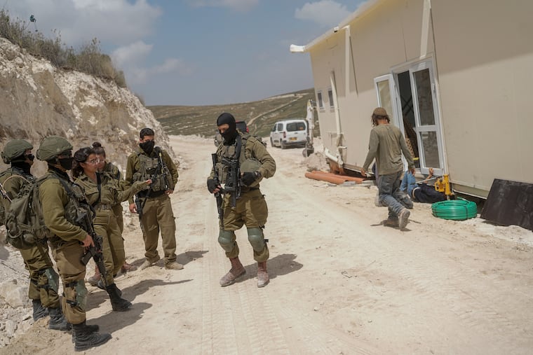 Israeli soldiers secure the construction site as Jewish settlers work at a seminary that was built overnight in the West Bank outpost of Homesh on Monday. Settlers built the religious school months after Israel's far-right government repealed a 2005 act that had dismantled the outpost.