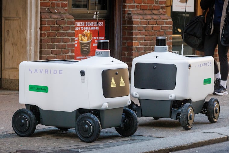 Uber Eats robot food delivery pods on sidewalk along 1500 Sansom Street on Tuesday morning March 17, 2026. One robot was present (right) when a second arrived.