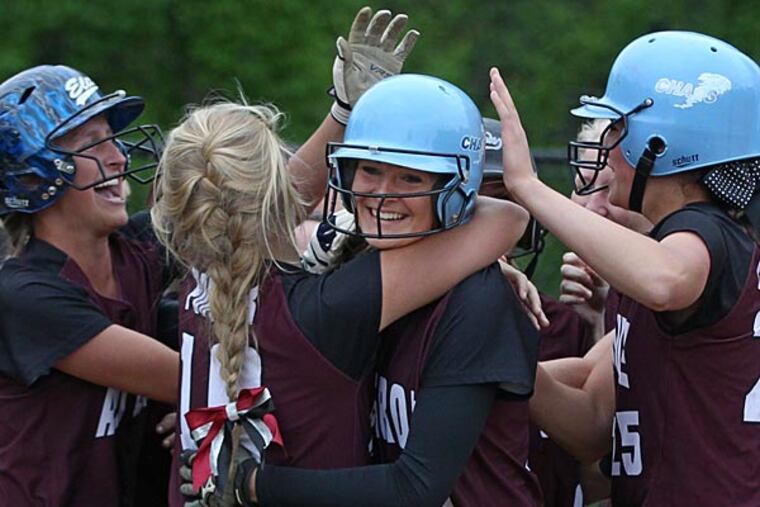 Avon Grove's #11, Alyssa Herion, center, is mobbed by her teammates as
she crosses home plate after a two run home run that tied the score
2-2 in the bottom of the first inning. Avon Grove beats North Penn
4-2 to win the Class AAAA softball championship on Thursday at Great
Valley. 05/28/2014 ( Michael Bryant / Staff Photographer )