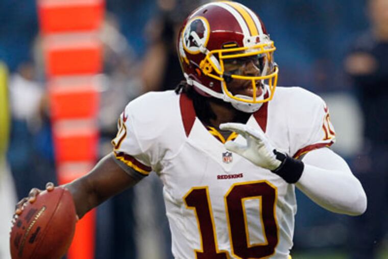 Washington Redskins quarterback Robert Griffin III looks for a
receiver against the Chicago Bears in the first half of an NFL
preseason football game in Chicago, Saturday, Aug. 18, 2012. (AP
Photo/Charles Rex Arbogast)