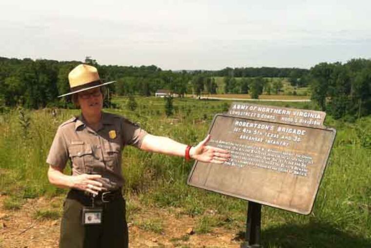 Katie Lawhon, public information officer for Gettysburg Battlefield National Military Park explains how tree clearing opened up views at Devil's Den. Staff photo by Amy Worden