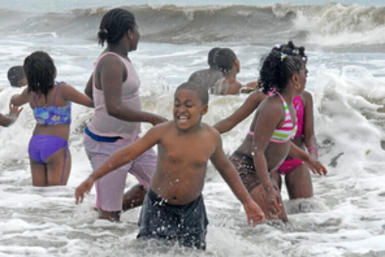 John Gregory, 7, feels ocean surf for the first time in Ocean City, N.J., where a nonprofit program welcomes inner-city children.