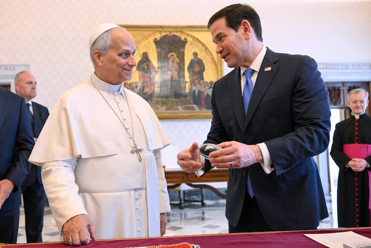 Pope Leo XIV exchanges gifts with Secretary of State Marco Rubio as they meet Thursday in the pope's private library at the Vatican.