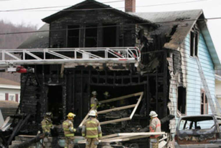 Firefighters bring supports through the front of the house.The blaze claimed the lives of members of three generations.