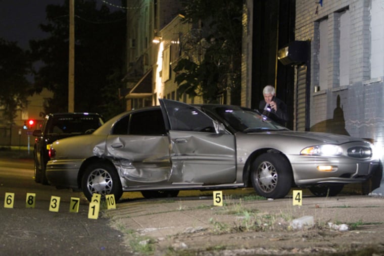 Investigators gather on Glenwood Avenue near 22nd Street in North Philadelphia on Tuesday Aug. 20, 2013, after police shot and killed a man who was allegedly pointed a loaded handgun at officers. Police said they recovered and .357-caliber revolver and a 9 mm handgun from the suspect car. (For the Daily News/ Joseph Kaczmarek)