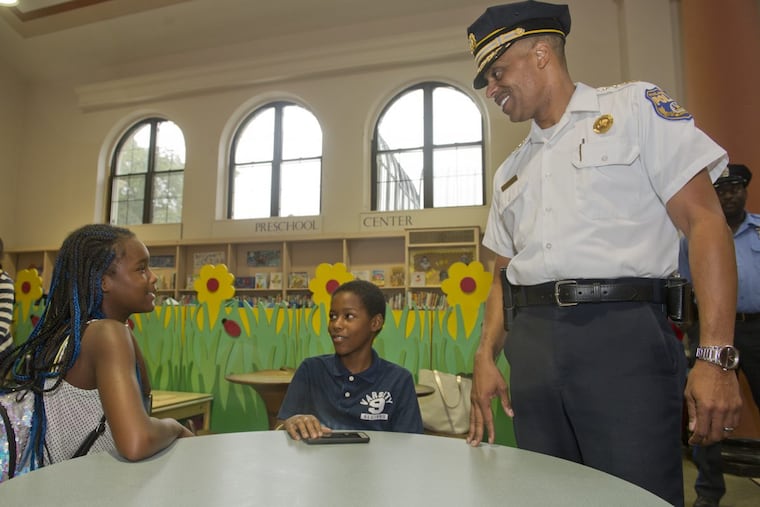 Police Commissioner Richard Ross speaks with twins Christina and Christian Grierson, 10, at the McPherson Square Library.