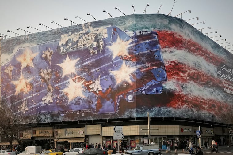 A billboard depicting a damaged U.S. aircraft carrier with disabled fighter jets on its deck and a sign reading in Farsi and English, "If you sow the wind, you'll reap the whirlwind," is seen at Enqelab-e-Eslami (Islamic Revolution) Square in Tehran, Iran, Sunday, Jan. 25, 2026.