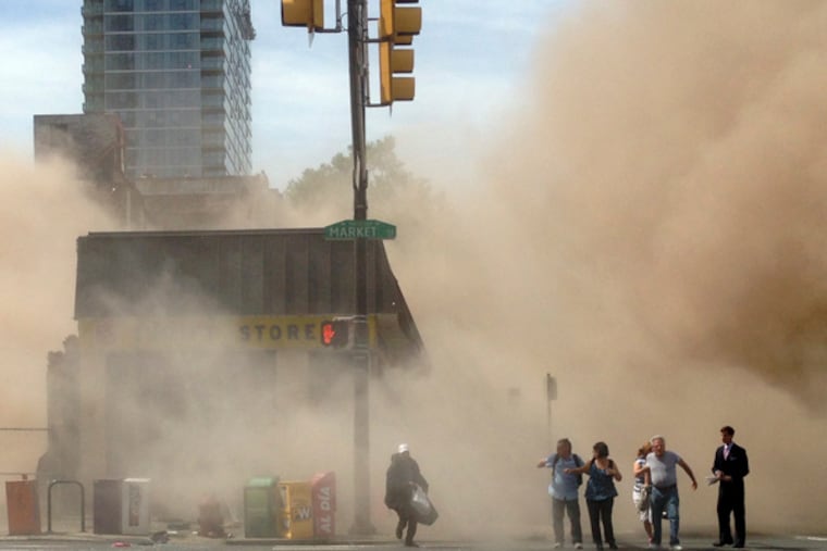 FILE - In this file photo provided by Jordan McLaughlin, a dust cloud rises as people run from the scene of a building collapse on the edge of downtown Philadelphia on Wednesday, June 5, 2013. An official says an inspector who surveyed a Philadelphia building before it collapsed last week, killing six people, has committed suicide. Deputy Mayor Everett Gillison says the inspector was found fatally shot in a pickup truck Wednesday night, June 12, 2013. The man was a Department of Licenses and Inspections employee who had inspected the building May 14. (AP Photo/Jordan McLaughlin, File)