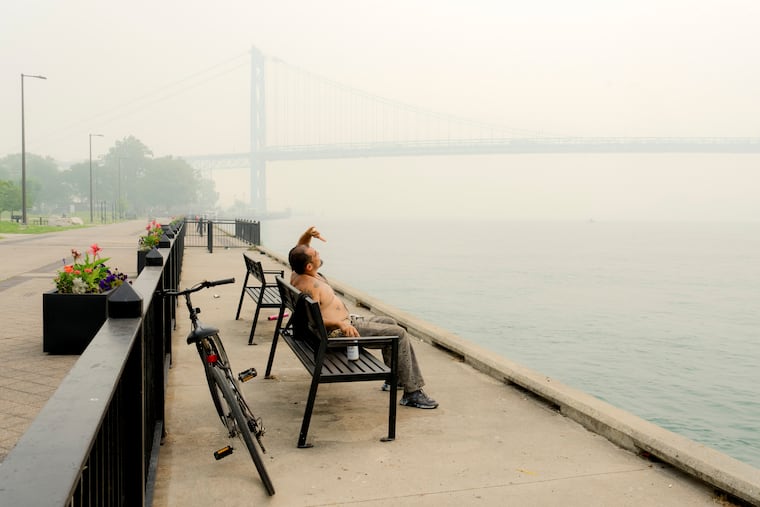 NYTSELECTS – A man looks up into the sky filled with smoke from Canadian wildfires along the Detroit River near the Ambassador Bridge to Canada in Detroit, on Thursday, July 16, 2026. Air quality in several cities reached hazardous levels on Thursday morning as smoke is expected to move across North America. (Nic Antaya/The New York Times)