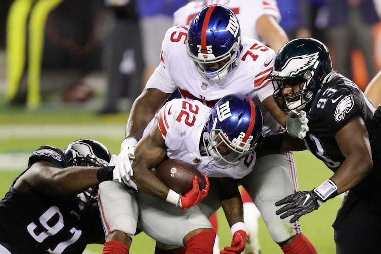 Fletcher Cox (91) and Javon Hargrave converge on Giants running back Wayne Gallman last season.