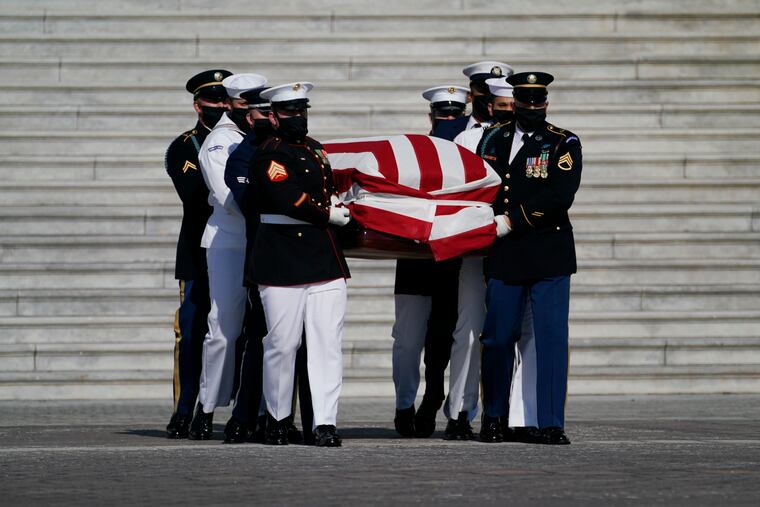 The flag-draped casket of the late Rep. John Lewis, D-Ga., is carried by a joint services military honor guard from Capitol Hill, Wednesday, July 29, 2020, in Washington.