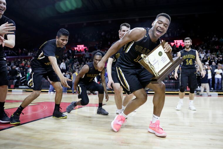 Moorestown’s Nick Cartwright-Atkins (with trophy) celebrates with teammates after winning Group 3 state title.