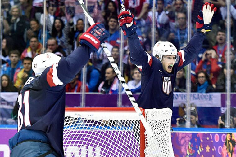 United States forwards Phil Kessel, left, and James van Riemsdyk, right, celebrate Cam Fowler's goal against Russia during second period preliminary round hockey action at the 2014 Sochi Winter Olympics in Sochi, Russia on Saturday, Feb. 15, 2014. (AP Photo/The Canadian Press, Nathan Denette)