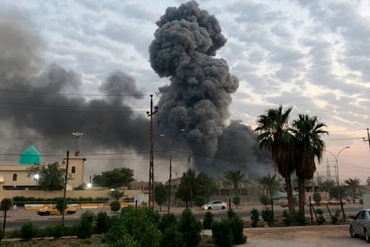 FILE - In this Monday, Aug. 12, 2019 file photo, plumes of smoke rise after an explosion at a military base southwest of Baghdad, Iraq. A fact-finding committee appointed by the Iraqi government to investigate a massive munitions depot explosion near the capital Baghdad has concluded that the blast was the result of a drone strike. A copy of the report was obtained by The Associated Press Wednesday, Aug. 21, 2019.