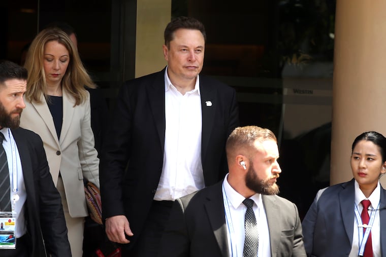 Elon Musk (center) arrives for the 10th World Water Forum in Nusa Dua, Bali, Indonesia, on May 20. A group of Tesla shareholders are asking investors to vote against a compensation package worth more than $50 billion for CEO Elon Musk, saying that it's not in the electric vehicle maker's best interest.