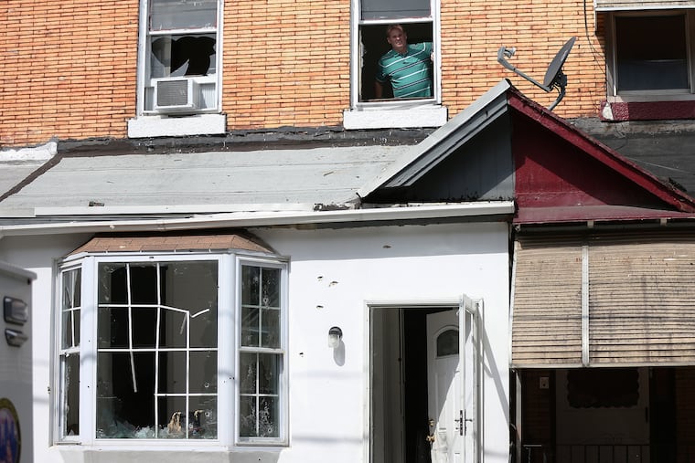 A detective looks out the window of the home in the 3700 block of North 15th Street, where Maurice Hill allegedly shot and wounded six police officers during an hours-long standoff Wednesday, in North Philadelphia on Saturday, Aug. 17, 2019. Hill was charged with attempted murder Saturday.