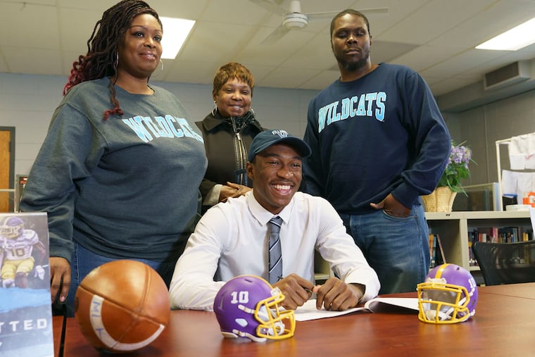 Martin Luther King's Tyrell Mims (seated) with (from left) his mother, Rasheedah Mims;, grandmother, Inga Mims; and stepfather, Ronald Conner, after signing a national letter of intent with Villanova.