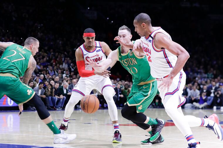 Sixers forward Tobias Harris passes the basketball to teammate center Al Horford past Boston Celtics forward Gordon Hayward and forward Daniel Theis (left) on Thursday, January 9, 2020 in Philadelphia.