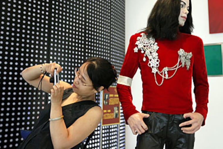 A visitor next to a wax figure of Michael Jackson at the Madame Tussauds Wax Museum in Shanghai. Jackson's death at the age of 50 has captured worldwide attention. (AP Photo/Eugene Hoshiko)