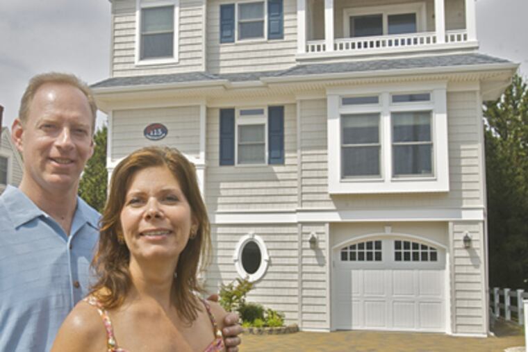 Adrienne Drost with her husband, Joe, outside their Shore home in North Beach Haven. The Drosts remade a 50-year-old Cape, which was literally sinking into the sand. The remade home came with a new foundation. (John Costello / Staff Photographer)