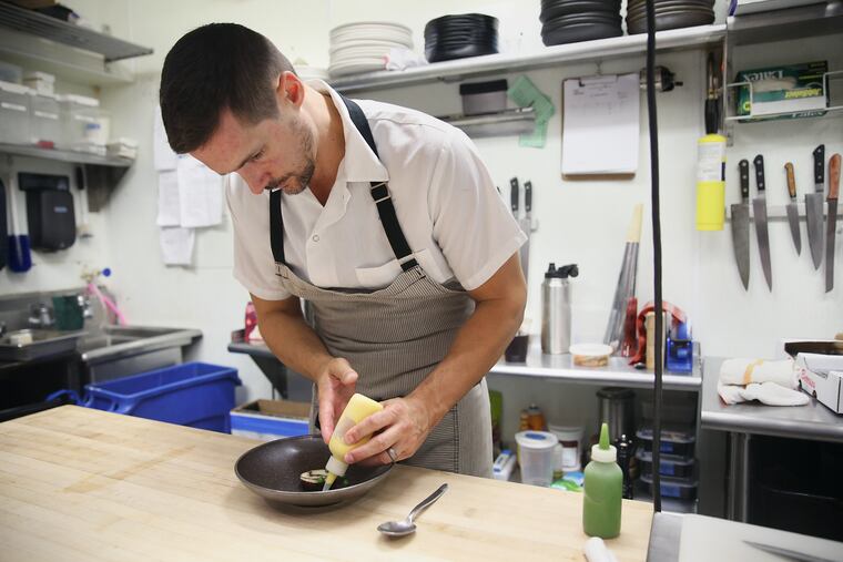 Chef-owner Nicholas Elmi plates the striped bass torchon at Laurel in Philadelphia's East Passyunk neighborhood on Thursday, Aug. 16, 2018.